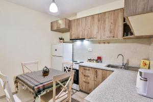 a kitchen with a table and a white refrigerator at Basilica Apartments in Budva