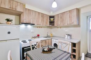uma cozinha com armários de madeira, uma mesa e um lavatório em Basilica Apartments em Budva