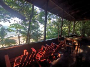 Pokój z krzesłami i stołem z widokiem na plażę w obiekcie Pirate Drake Beach Camp & Tour company w mieście Bahía Drake