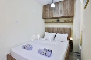 um quarto com uma cama branca com duas almofadas em Basilica Apartments em Budva