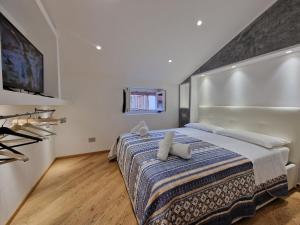 ein Schlafzimmer mit einem großen Bett und einem Flachbild-TV in der Unterkunft HomeHoliday LUXE - MY PLACE SANREMO in Sanremo