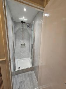 een badkamer met een douche en een bad bij London Mile End Rooms in Londen