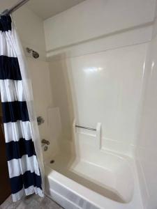 ein weißes Bad mit einer Dusche und einer Badewanne in der Unterkunft 201 E Veterans St Apt G by Patriot Properties in Tomah