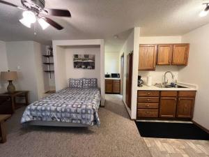 a bedroom with a bed and a kitchen with a sink at 201 E Veterans St Apt G by Patriot Properties in Tomah