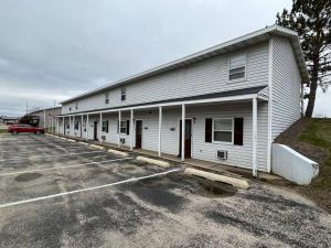 a large white building with a parking lot at 201 E Veterans St Apt G by Patriot Properties in Tomah