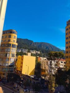 uma cidade com edifícios e uma montanha ao fundo em La Candelaria Centro Histórico - Cozy Room Bogotá em Bogotá