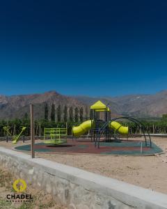 a playground with a yellow slide in a park at Chadel Management Cafayate in Cafayate