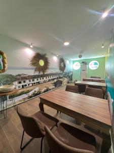 a restaurant with tables and chairs and a train mural at Hotel Florida in Durrës