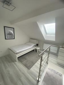 a white room with a bed and a window at Apartmány DEER House in Hodkovice nad Mohelkou