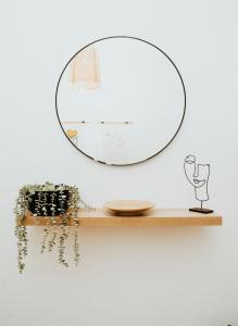 a mirror on a wall with a wooden shelf at Sotiris House in Kazaphani