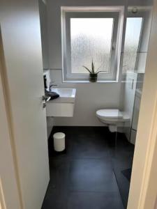 a bathroom with a sink and a window and a toilet at Wohnung am CentrO! in Oberhausen