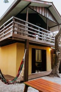 a house with a hammock in front of it at Casa Alegria da Ilha in Paranaguá