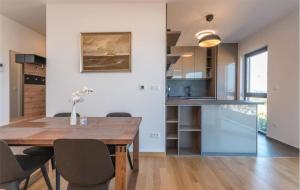 a kitchen and dining room with a wooden table and chairs at DVJ Apartments 3 in Sveti Filip i Jakov
