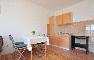 eine Küche und ein Esszimmer mit einem Tisch und Stühlen in der Unterkunft Stunning Apartment In Lokva Rogoznica With Wifi in Lokva Rogoznica