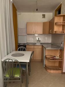 a kitchen with a table and a table and chairs at Cozy apartament in Tbilisi City
