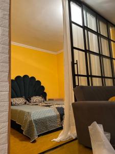 a bedroom with a bed and a large window at Cozy apartament in Tbilisi City