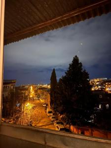 a view of a city at night from a window at Cozy apartament in Tbilisi City