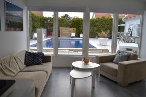 een woonkamer met een bank, een tafel en een zwembad bij Calm villa-apartement near the sea and nature in Klagshamn