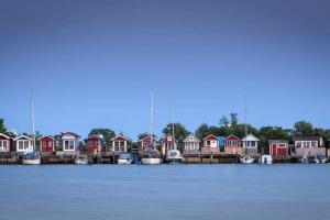 a group of houses on the water with boats at Calm villa-apartement near the sea and nature in Klagshamn