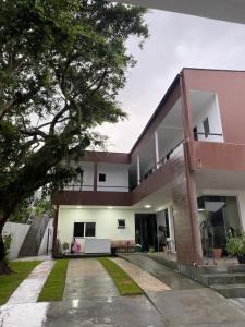 a modern house with a courtyard and a tree at Pousada tamatoa in Florianópolis