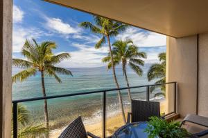 um quarto com vista para a praia e palmeiras em Mahana 517 em Kahana