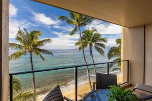 Cette chambre offre une vue sur la plage et les palmiers. dans l'établissement Mahana 517, à Kahana