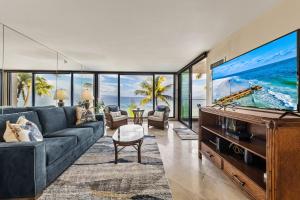 - un salon avec une grande télévision et un canapé dans l'établissement Mahana 517, à Kahana