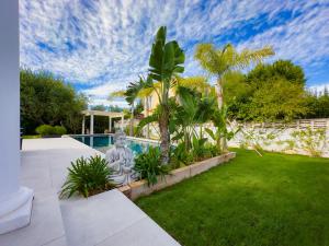 un jardín con una estatua junto a una piscina en Exclusive Villa Valencia - Denia Els Poblets, en Els Poblets