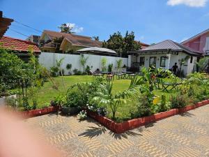 einen Garten mit Tischen und Stühlen und ein Haus in der Unterkunft Gardens Apartment in Accra