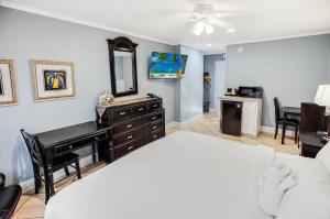 1 dormitorio con cama, escritorio y espejo en Rejuvinating 2nd flr Resort View King Room, en Pawleys Island