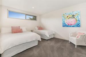Un dormitorio con dos camas y un cuadro en la pared. en On The Bay Blairgowrie, en Blairgowrie