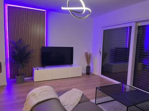 sala de estar con TV e iluminación púrpura en Moderne Wohnung am Rhein, en Coblenza
