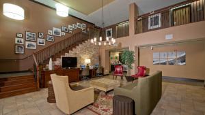 ein Wohnzimmer mit Stühlen und einer Treppe in der Unterkunft Russell Inn and Suites in Starkville