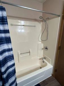 y baño con bañera y cortina de ducha. en 201 E Veterans Street Apt B en Tomah