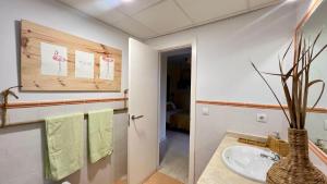 a bathroom with a sink and a vase with a plant at Casa Pez in Ayamonte +64 photos