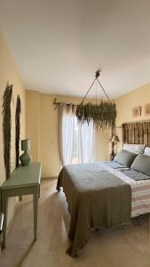 a bedroom with a bed and a table and a window at Casa Pez in Ayamonte