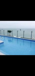 利馬的住宿－Panoramic Condominio，一个大型的游泳池,背景是大海