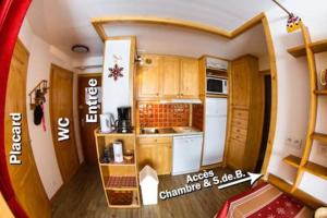 a small kitchen with wooden cabinets in a room at Les Menuires coeur de station in Les Menuires