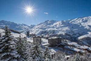 a view of a city with snow covered mountains at Les Menuires coeur de station in Les Menuires