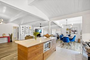 cocina abierta y sala de estar con sillas azules en Valley Glen Getaway, en Van Nuys