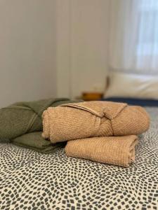 a pile of towels sitting on top of a bed at Acogedor piso a un paso de Granada Capital. in Granada