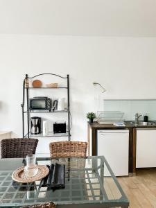 a kitchen with a glass table and some chairs at SEEBADHOF - Landhaus Kaiser in Rangsdorf
