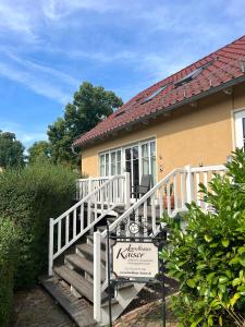 una casa con una escalera blanca que conduce a la puerta principal en SEEBADHOF - Landhaus Kaiser, en Rangsdorf