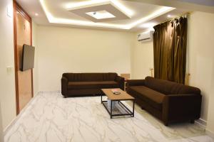 uma sala de estar com dois sofás e uma mesa em بيوت عطلات دور المصيف للضيافة السياحي em Qarār