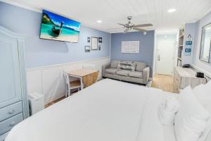 a bedroom with a large white bed and a couch at Tranquil 3rd Flr Resort View King Room in Pawleys Island
