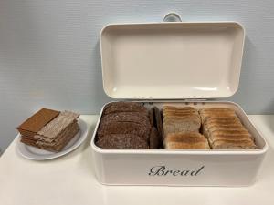 a white container filled with different types of bread at Gästhem Neptun in Mariehamn