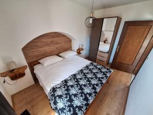 Schlafzimmer mit einem großen Bett mit einem Kopfteil aus Holz in der Unterkunft Apartment Modric in Lovranska Draga