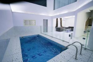 een groot zwembad in een witte kamer met bij بيوت عطلات دور المصيف للضيافة السياحي in Qarār