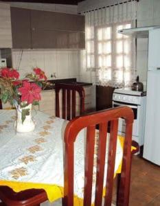 uma cozinha com uma mesa com um vaso de flores em Casa Capao da Canoa em Capão da Canoa