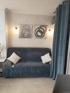 a blue couch in a living room with two paintings at Casa Playa de la Mata in La Mata